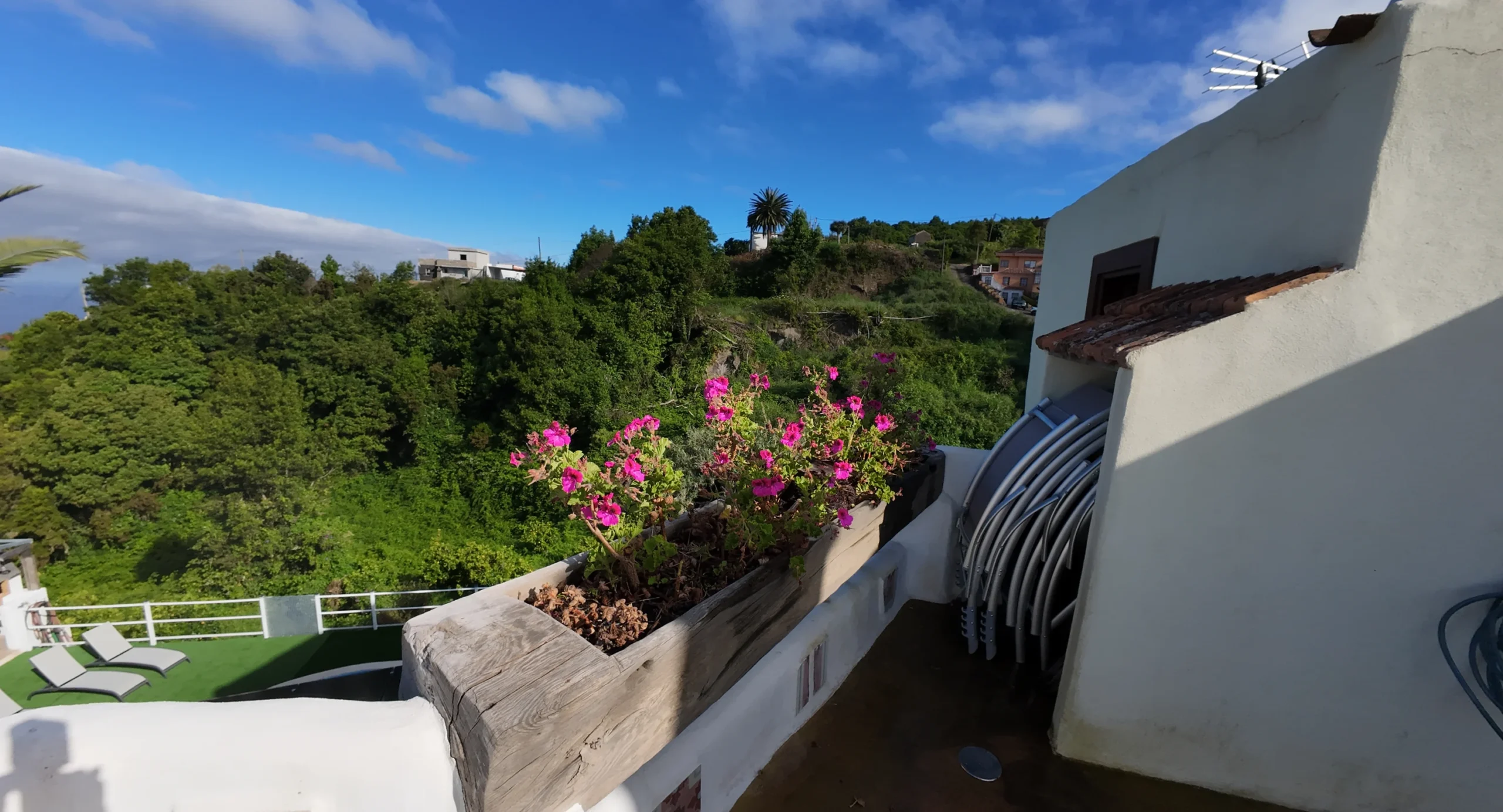 La azotea de Casa La Piedra con las flores y la vista sobre el barranco