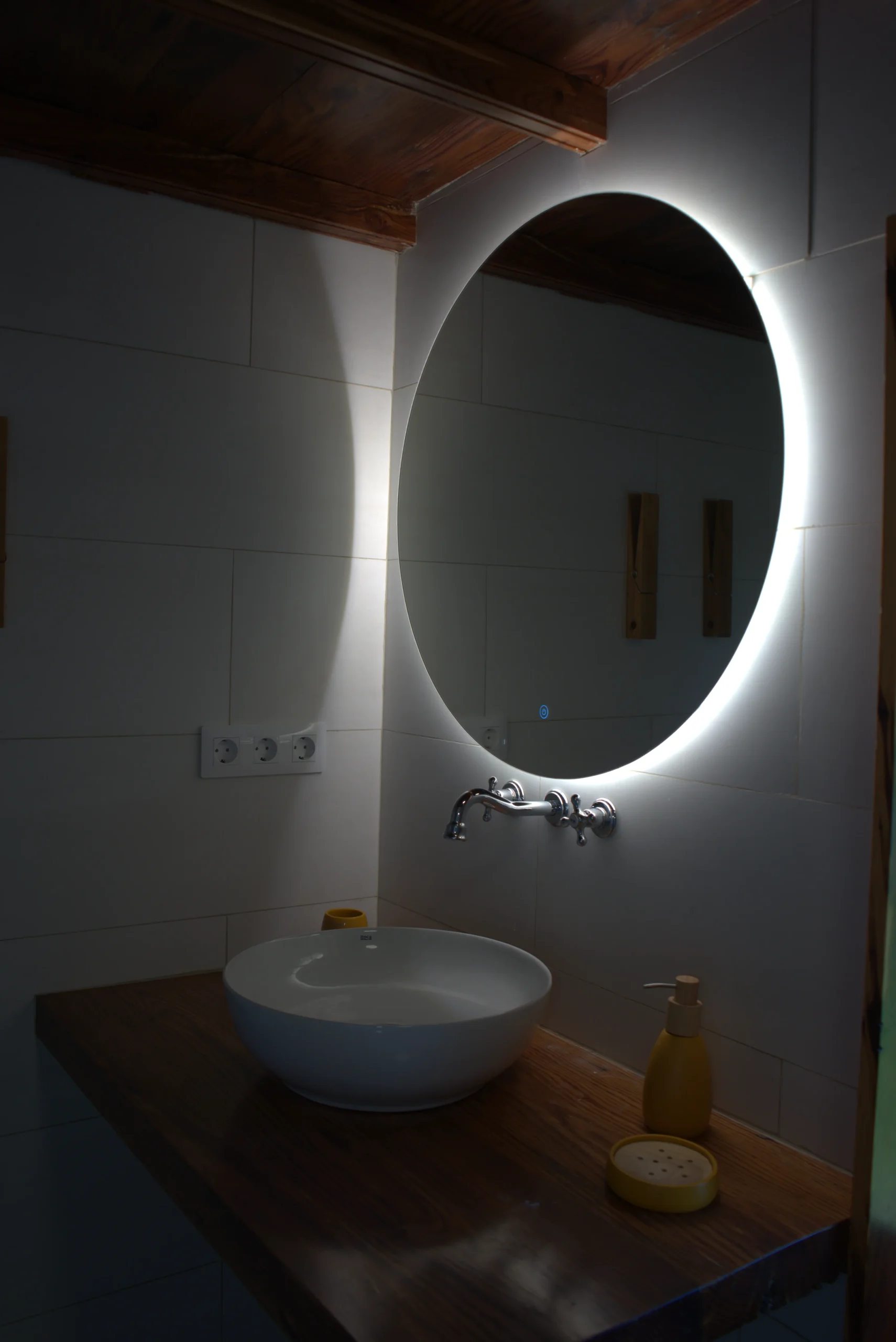 El baño de Casa La Piedra con el lavabo de piedra y el espejo ovalado