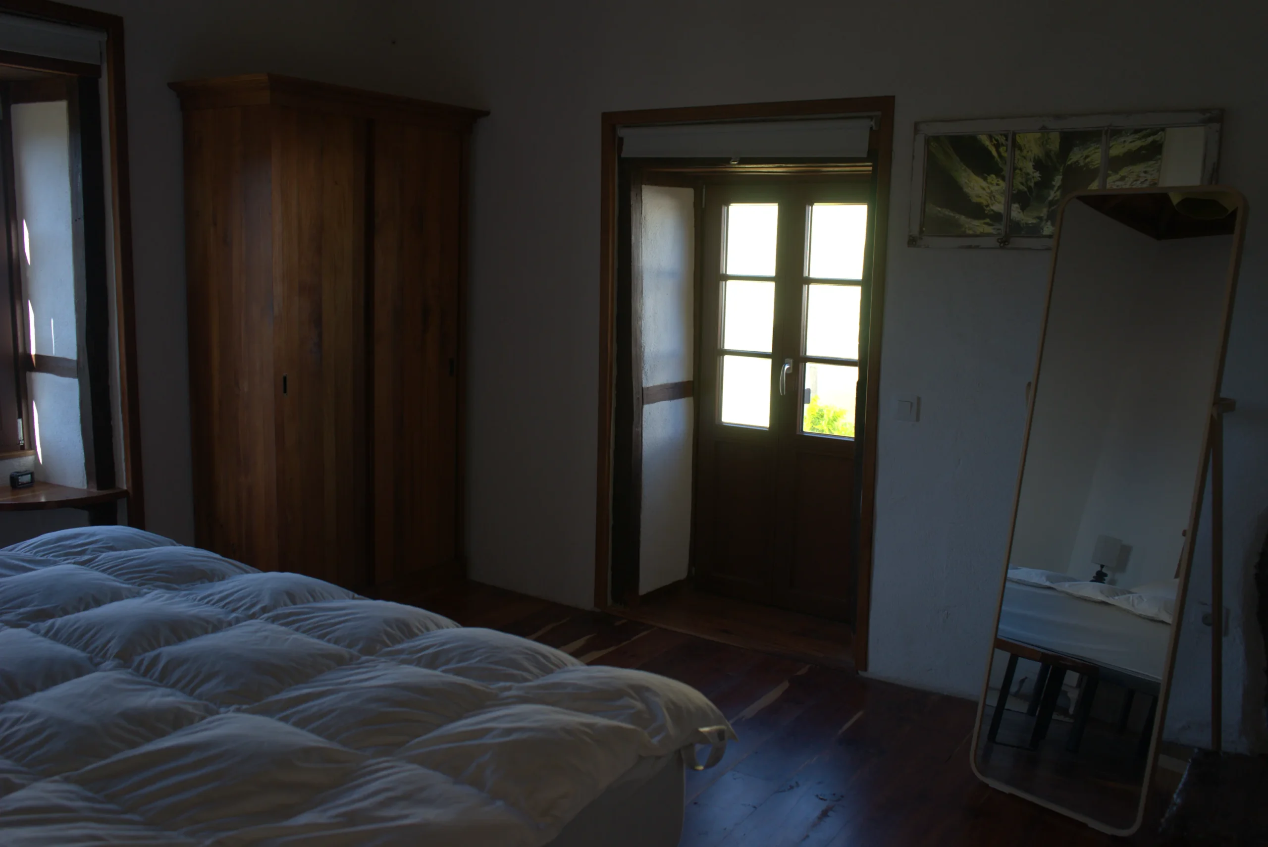 Dormitorio de Casa La Piedra con el armario de madera y el suelo de tea
