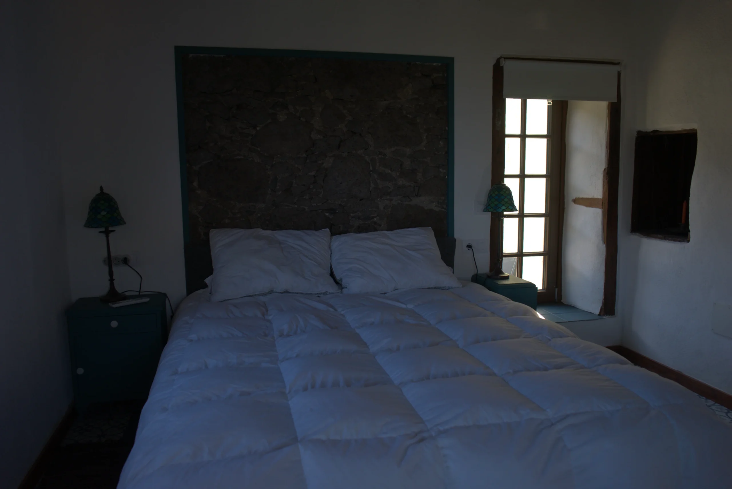 Dormitorio de Casa La Piedra con el cabecero tallado en la roca