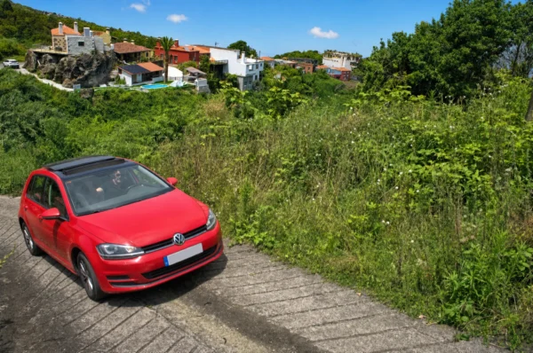 Un coche aparcado en el camino que sube a las casas, en La Galga