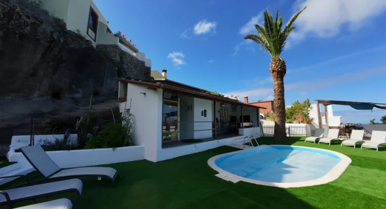 La piscina, la palmera y las tumbonas de Cha Miquela a pleno sol