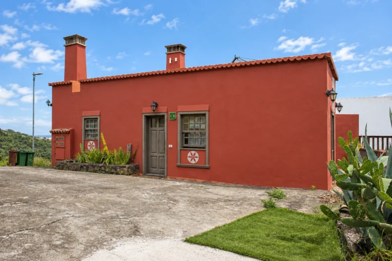 La fachada roja de Cha Miquela Roja con las ventanas de madera