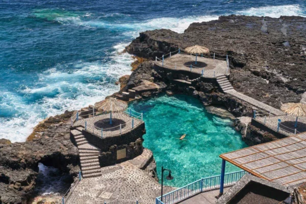 Las piscinas naturales del Charco Azul, con alguien bañándose en el agua turquesa
