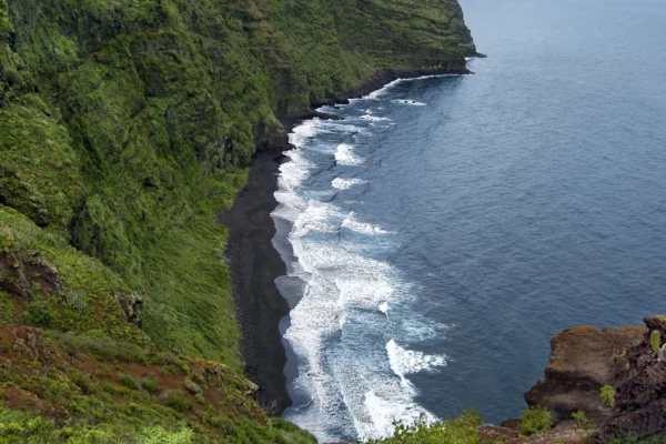 La playa de Nogales, de arena negra al pie del acantilado, en Puntallana