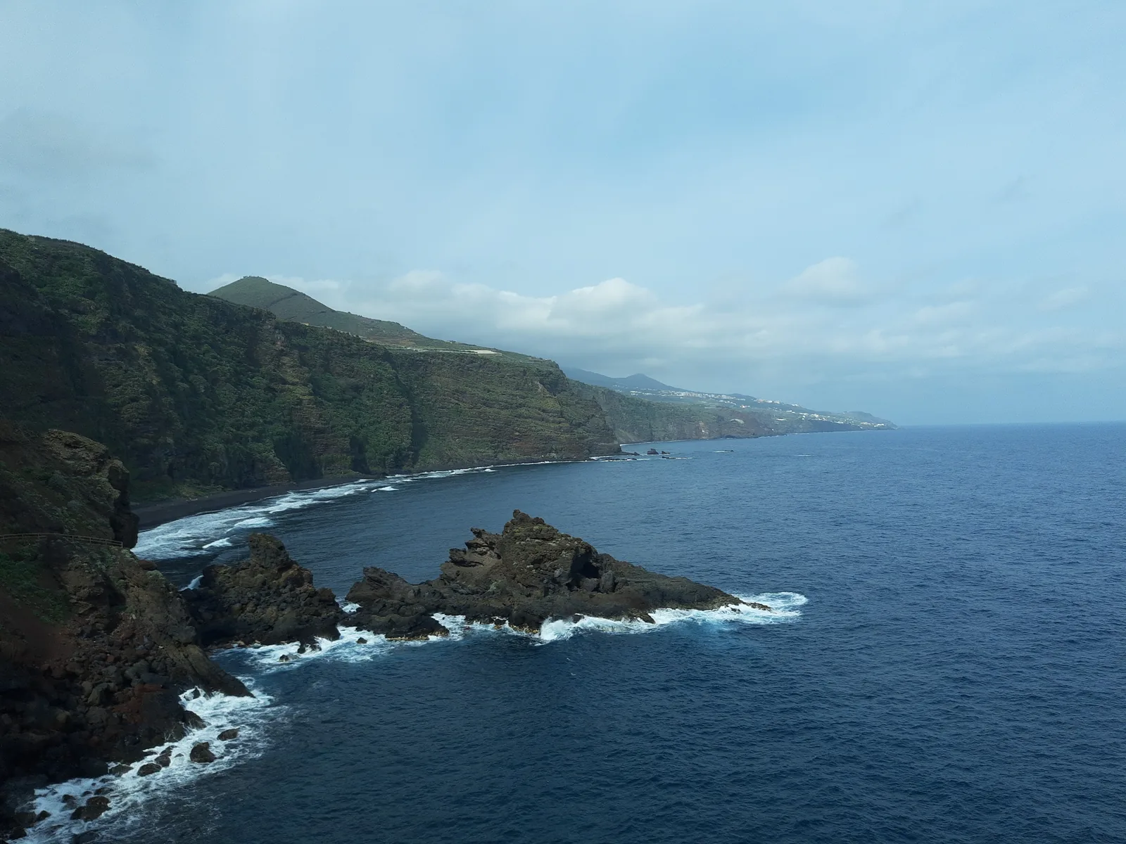 La costa de Puntallana con los roques de la playa de Nogales y el acantilado verde, bajo nubes